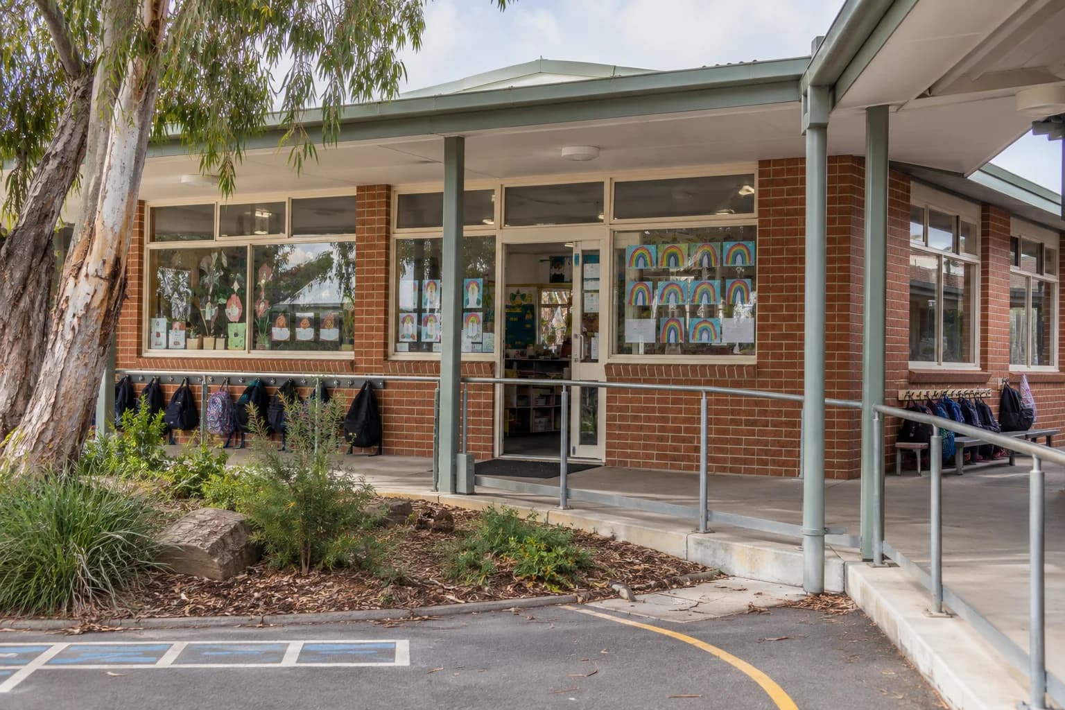 A primary school entrance with a covered veranda and established garden.